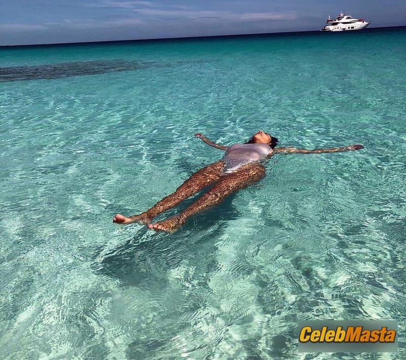 Kim Kardashian West enjoys her vacation alone, posing in a silver one-piece swimsuit on the beach Photo Gallery photo 3